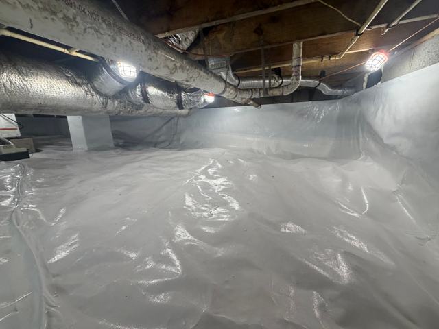 Completed crawl space encapsulation with white liner and work lights