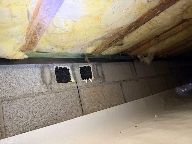 Foundation vents sealed with foam below old fiberglass insulation