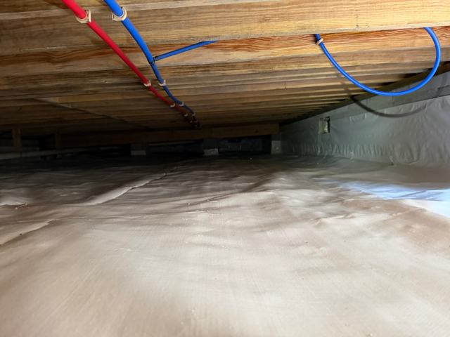 Fully encapsulated crawl space with white liner under PEX plumbing lines